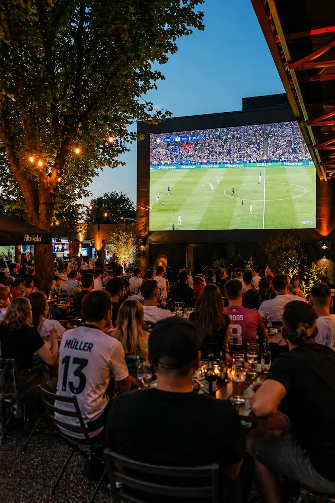 Menschen im Fußballtrikot beim Public Viewing